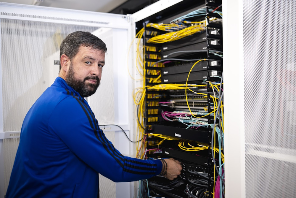 Un collègue du service informatique, devant des serveurs